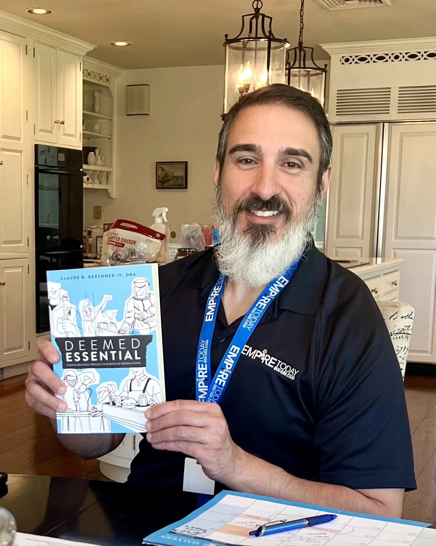 Trade-service professional holding a copy of Deemed Essential by Claude B. Kershner IV